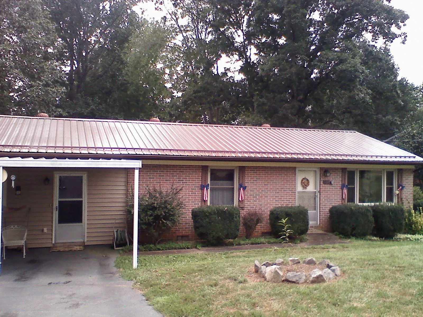 Bronze metal roof and carport on a brick ranch home — Roof Repair work by our crew in Cullowhee